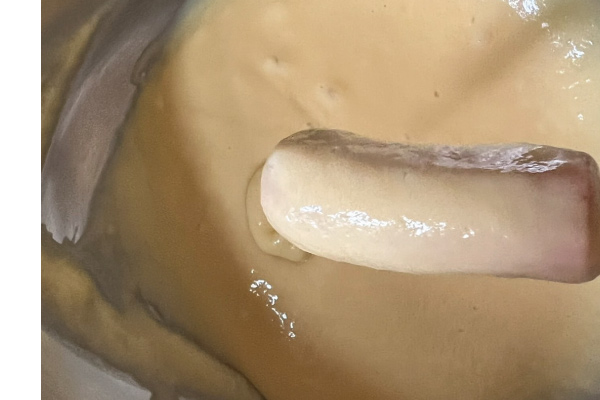 在麵糊中轉一圈，均勻沾上麵糊之後放入油炸鍋中。