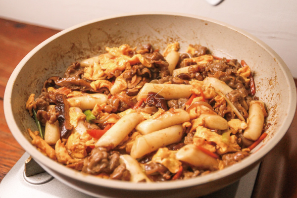 5.加入年糕（瀝乾）、醬汁、炒蛋，拌炒到收汁。