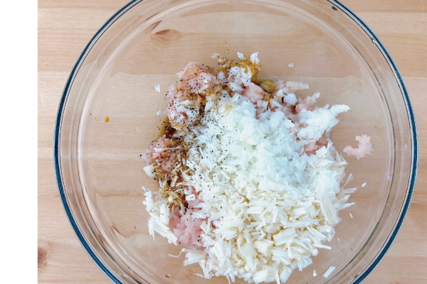 3.雞絞肉、碎洋蔥加入切小段的金針菇、鹽巴1/4小匙、適量白胡椒。