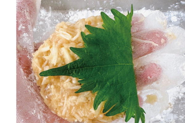 5.手可以抹點食用油防沾黏，取一球金針菇雞絞肉拍打成球狀，再壓成餅狀包上紫蘇葉。